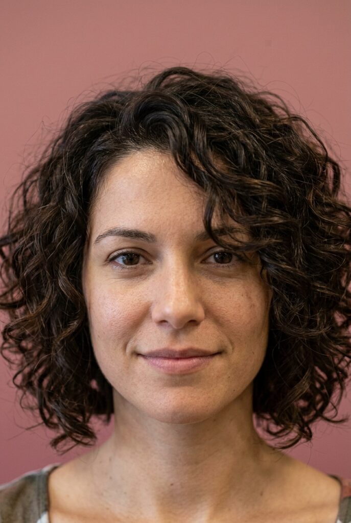 Woman with a curly lob hairstyle sitting between the shoulder and collarbone with defined waves